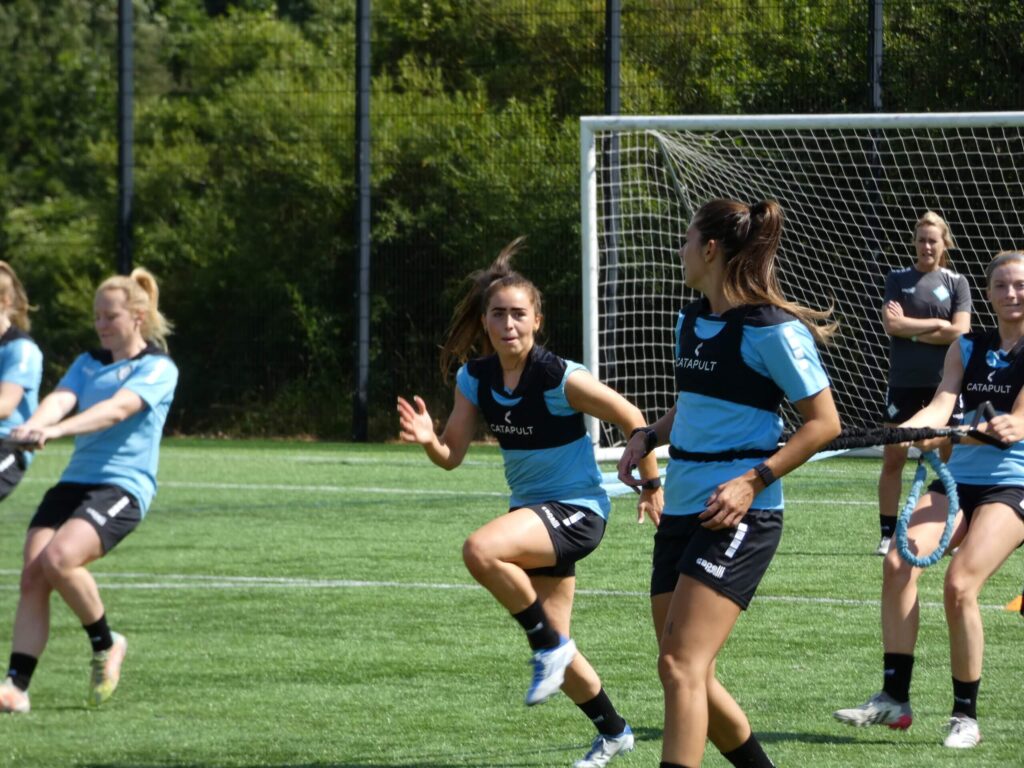 Le calciatrici delle London City Lionesses indossano i giubbotti Catapult durante una sessione di allenamento di resistenza sul campo.