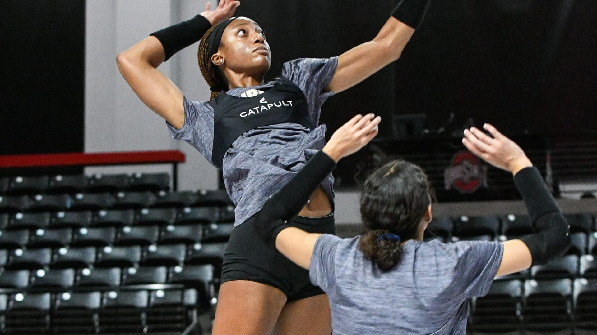 Purdue Volleyball player in mid-air attack during practice, wearing Catapult gear.